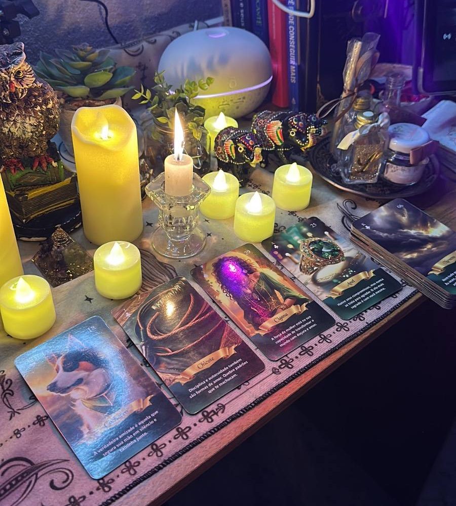 Mesa de atendimento com velas, planta e cartas de oráculo dispostas em tiragem