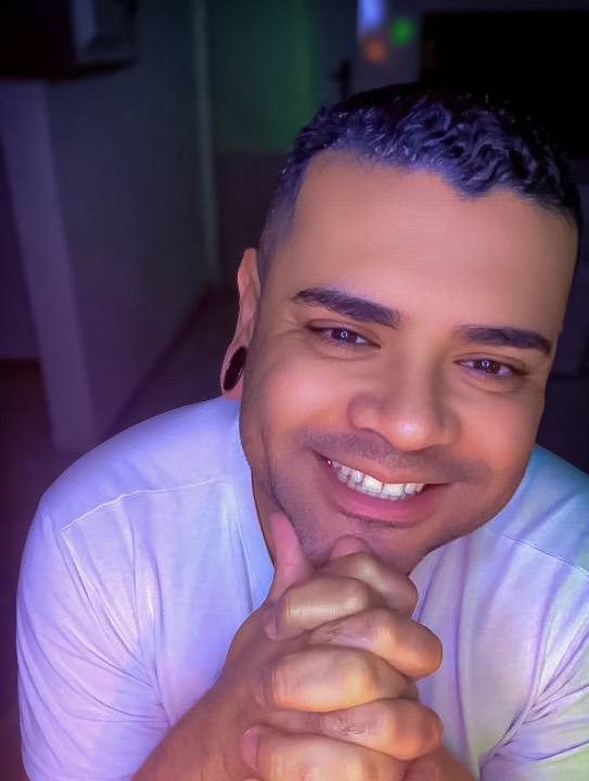 Felipe Araujo sorrindo com as mãos unidas diante do queixo